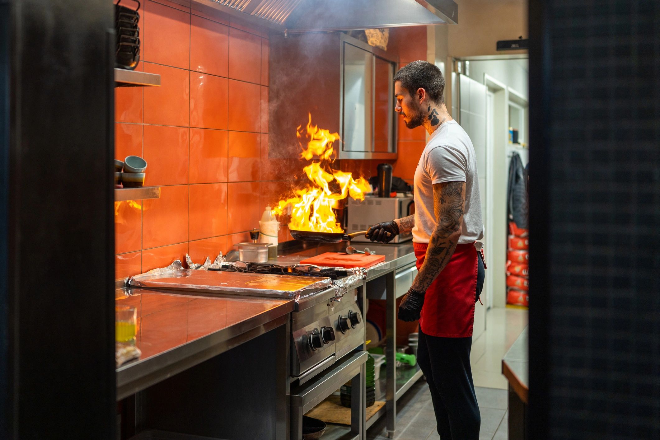 Chef cooking on a hot pan in a commercial kitchen